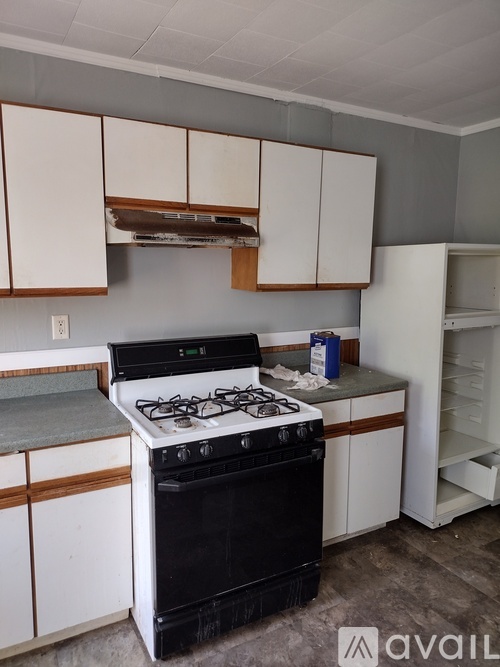 A kitchen with white cabinets and a stove top oven.