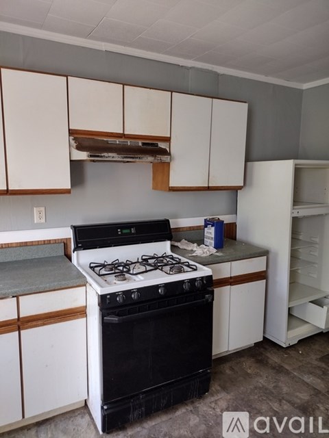 A kitchen with white cabinets and a stove top oven.