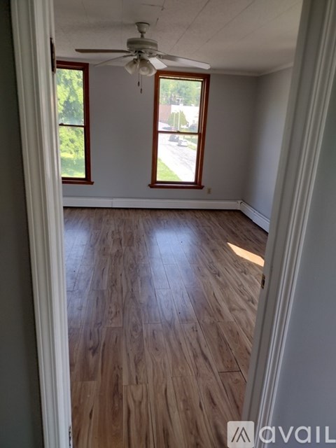 A room with wooden floors and a ceiling fan.