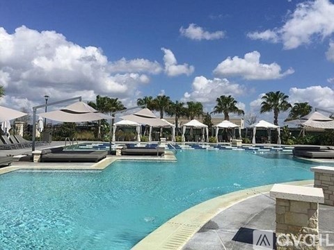 A large outdoor swimming pool surrounded by lounge chairs and umbrellas.