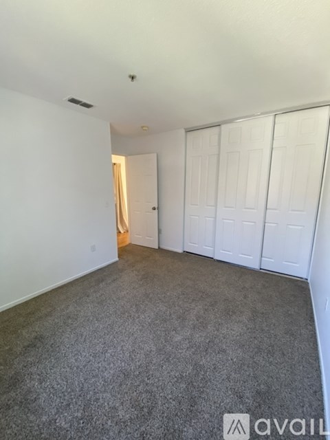 A room with a carpeted floor and a white door.