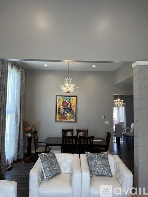 A living room with a white couch and a chandelier.