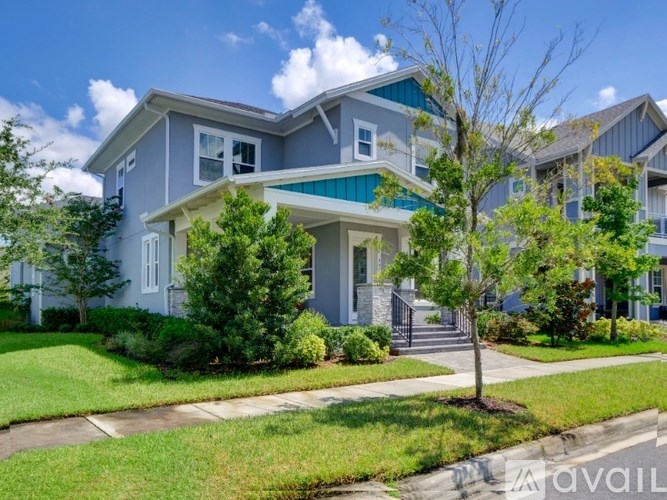 A modern two-story house with a well-maintained lawn and a tree in front.