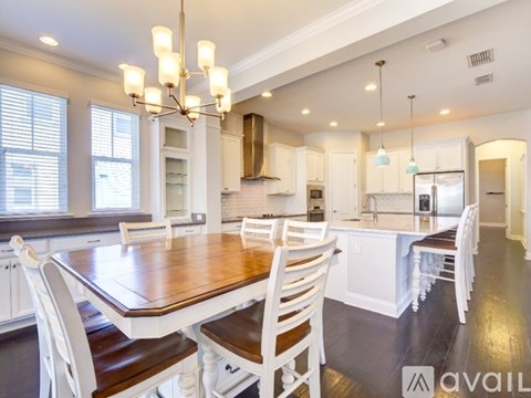 A modern kitchen with a wooden table and chairs.