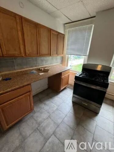 A kitchen with wooden cabinets and a black stove top oven.