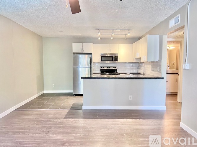 A kitchen with a refrigerator, microwave, and oven.