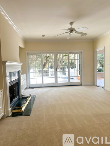 A living room with a fireplace and a fan.