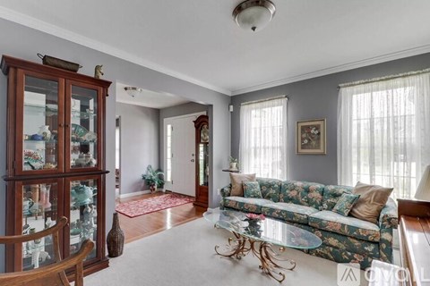 A living room with a floral sofa and a glass cabinet.