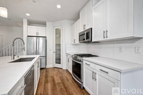 A kitchen with white cabinets and stainless steel appliances.