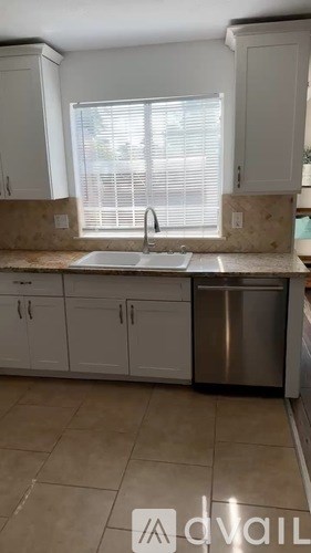 A kitchen with white cabinets and a stainless steel dishwasher.
