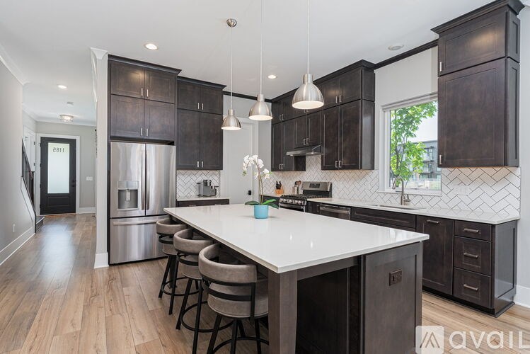 A kitchen with a white island and dark wood cabinets.