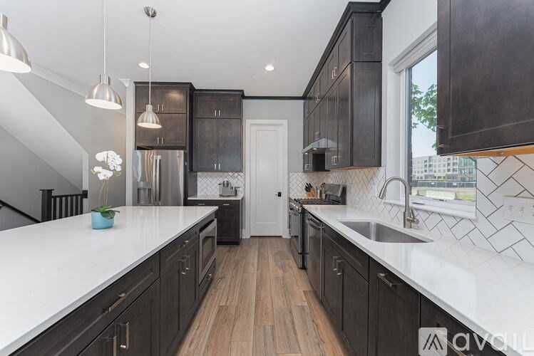 A modern kitchen with dark wood cabinets and white countertops.