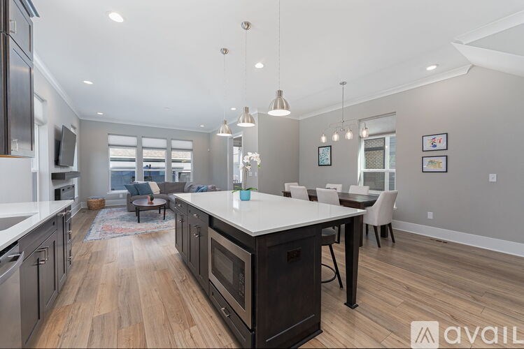 A modern kitchen with dark wood floors and a center island.