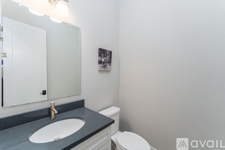 A bathroom with a sink, toilet and mirror.