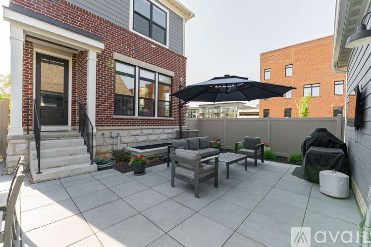 A patio with a table and chairs and an umbrella.