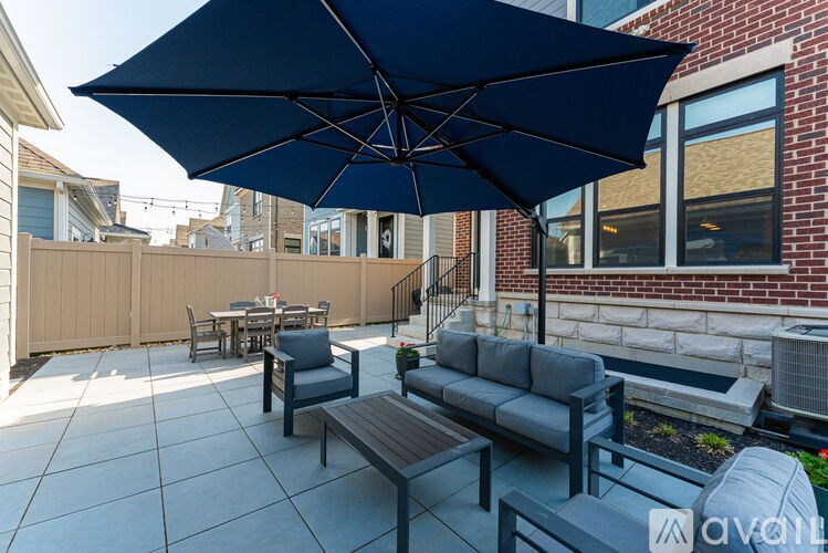 A patio with a table, chairs, and an umbrella.