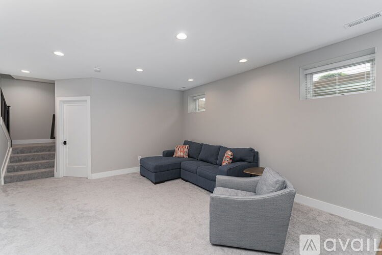 A living room with a grey sofa and a grey armchair.