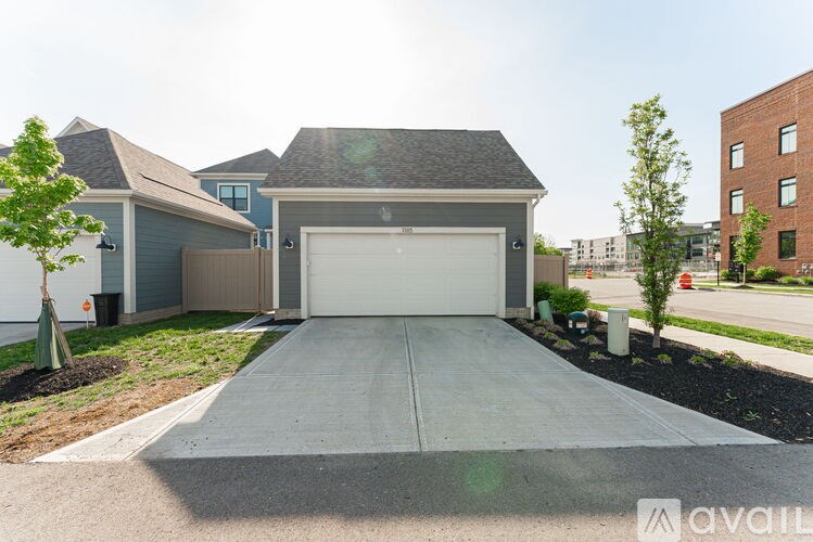 A house with a garage and a driveway in front of it.