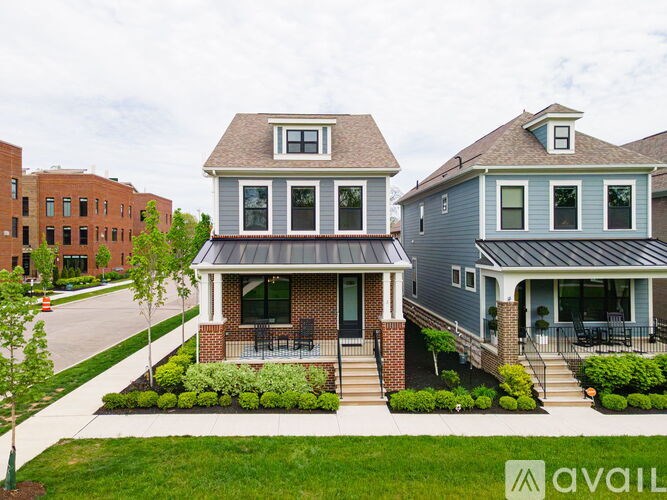 A house with a grey roof and a balcony is for sale.