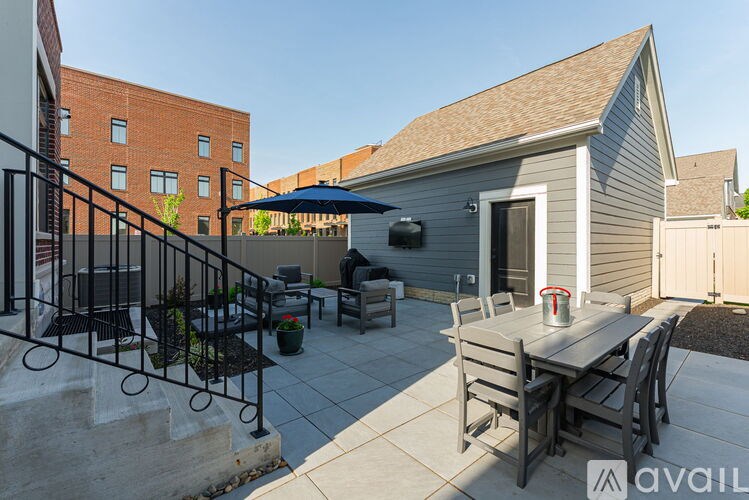A patio with a table and chairs is surrounded by a black railing.