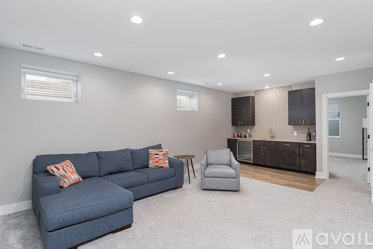 A living room with a blue couch and a grey armchair.