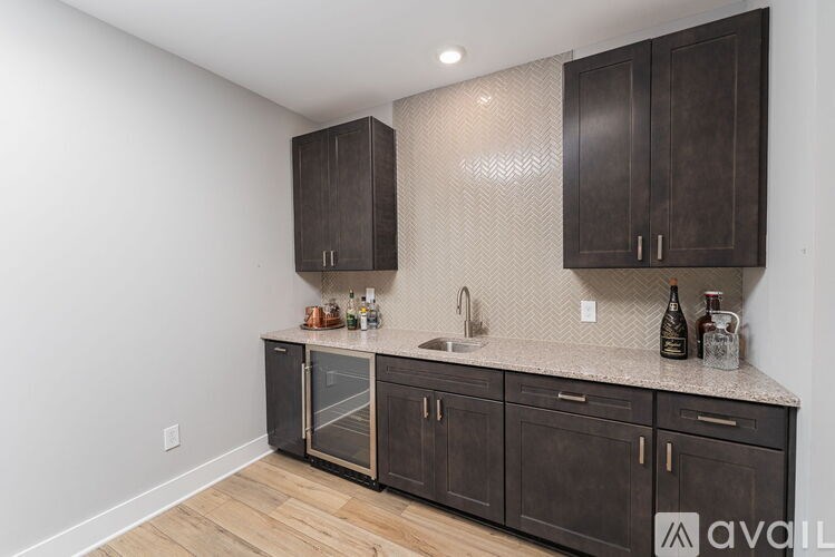 A kitchen with dark wood cabinets and a granite countertop.