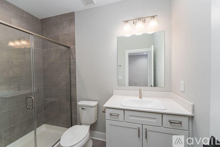 A bathroom with a toilet, sink, and shower.