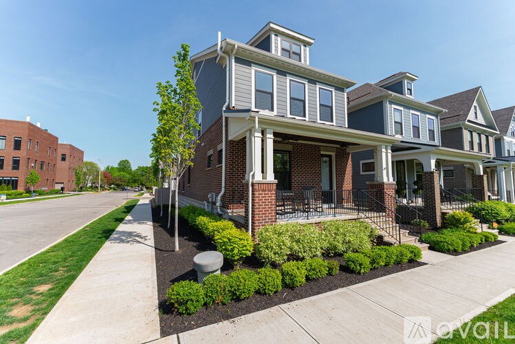 A modern two-story house with a front yard and landscaping.