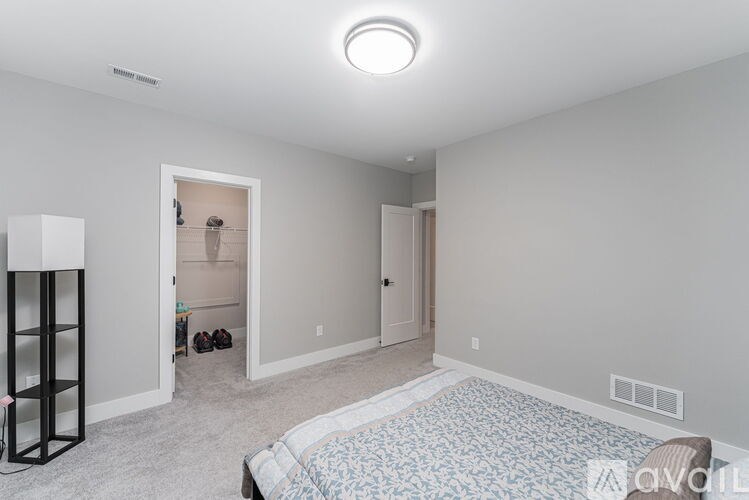 A bedroom with a bed, a dresser, and a wardrobe.