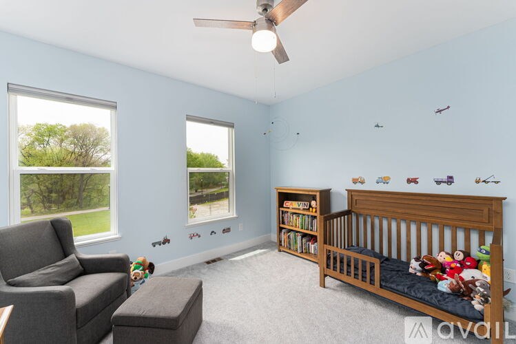 A baby's room with a crib, chair, and toys.