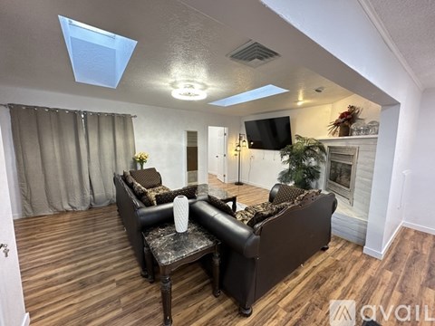 A living room with a black couch and a television.