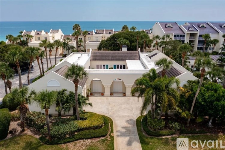 A white house with a palm tree in front of it.