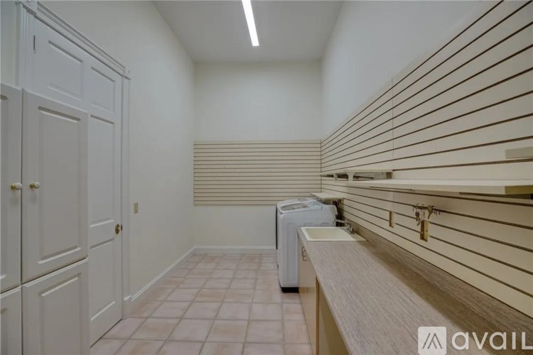 A laundry room with a washer and dryer and a bench.
