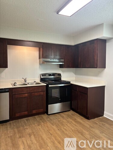 A kitchen with brown cabinets and a stainless steel oven.