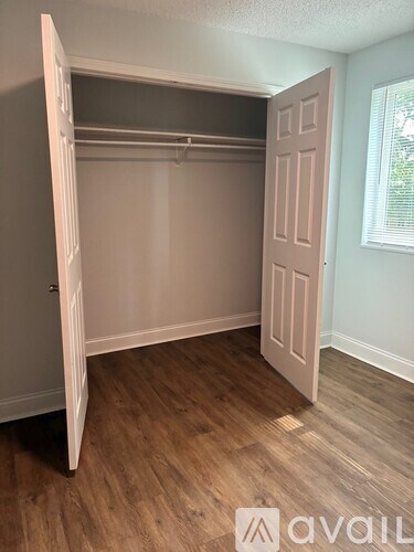 A room with a white closet and wooden floors.