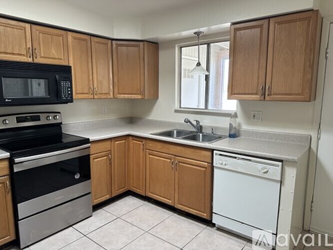 A kitchen with wooden cabinets and a black stove top oven.