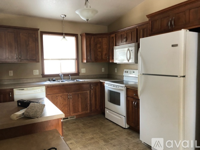 A kitchen with a white fridge and wooden cabinets.