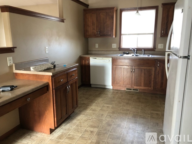 A kitchen with wooden cabinets and a white dishwasher.