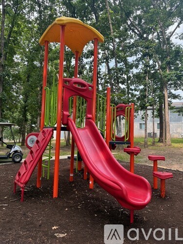 A red and yellow playground slide in a park.