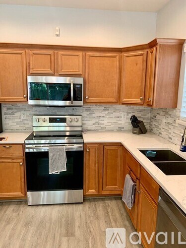 A kitchen with wooden cabinets and a stainless steel oven.