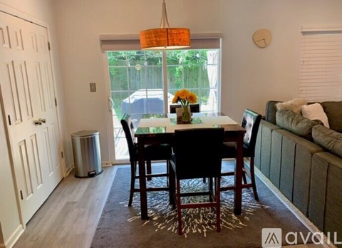A dining room with a table set for four and a couch.