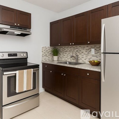 A kitchen with a stove, sink, and refrigerator.