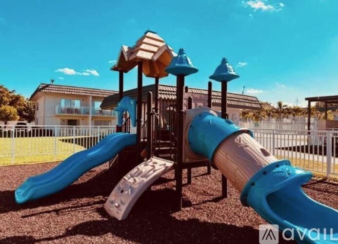 A playground with a blue slide and a wooden structure.