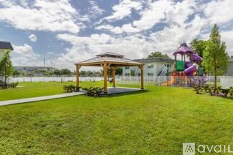 A backyard with a playground and a gazebo.