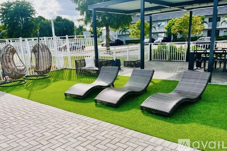 A patio area with two lounge chairs and a table.