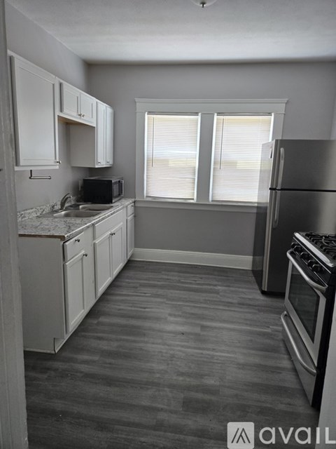 A kitchen with a refrigerator, oven, and microwave.