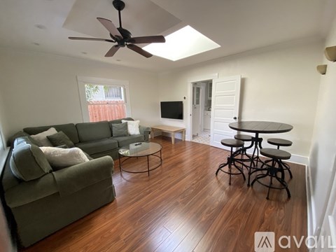 A living room with a grey couch and a round table.