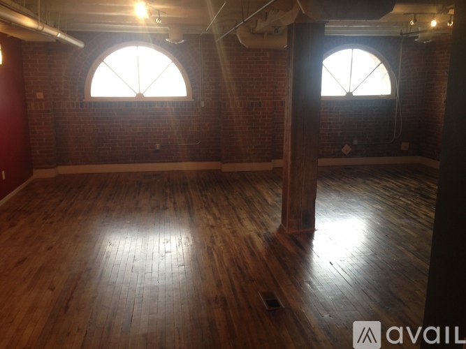 A room with wooden floors and two windows.