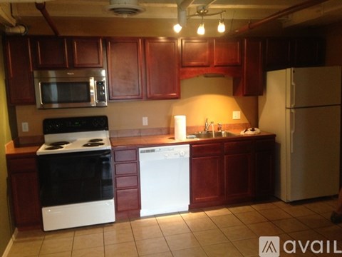 A kitchen with a black stove top oven, a white dishwasher, and a white refrigerator.