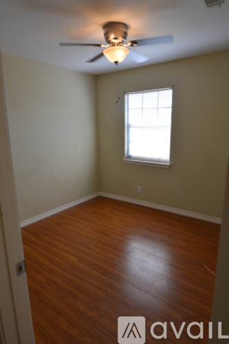 A living room with a staircase and a ceiling fan.